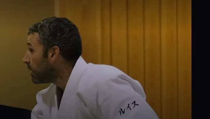 Luis Mochón, 6º Dan Aikikai, de perfil sobre el tatami con keikogi blanco durante un seminario de aikido